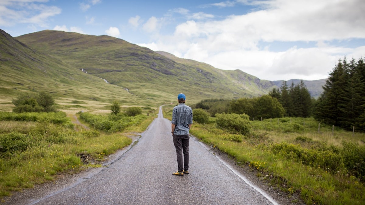 man standing on concrete road